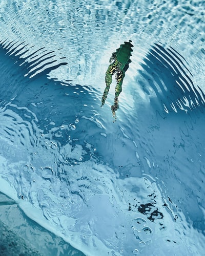 绿蛙在清水上游泳的高角度摄影